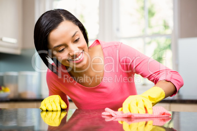 Smiling brunette cleaning kitchen counter