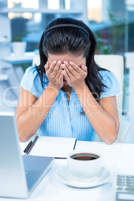 Worried businesswoman covering her face