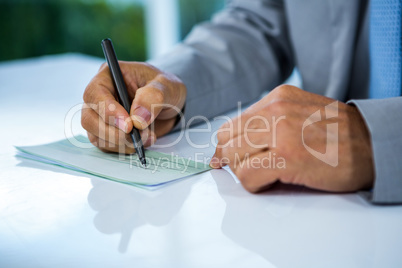 Businessman writing on paper