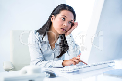 Exhausted businesswoman working on computer