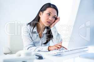 Exhausted businesswoman working on computer