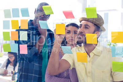 Businessman writing on adhesive note