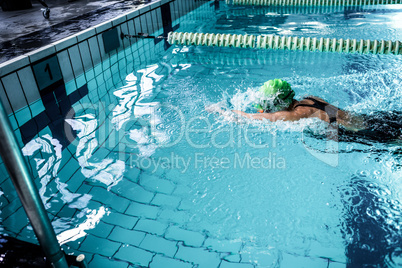 Fit woman swimming with swimming hat