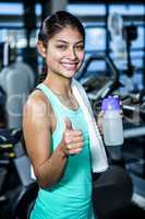 Smiling fit woman with thumbs up
