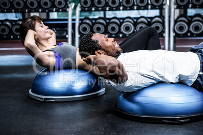 Fit couple doing bosu ball exercises