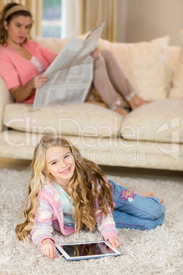 Happy mom and daughter lying on the floor