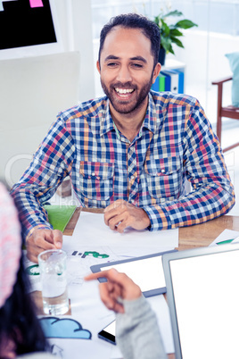 Happy man smiling while looking at colleague