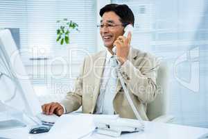 Smiling businessman talking on the telephone