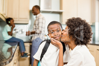Mother kissing son in the kitchen
