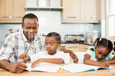 Father helping children for homework