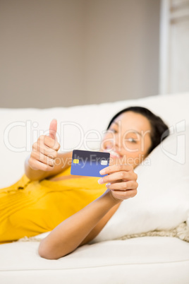 Smiling brunette showing credit card