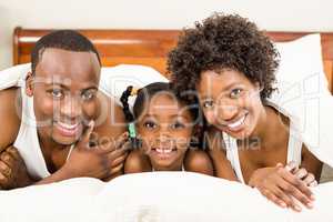 Smiling family lying in bed