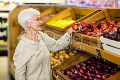 Senior woman picking out red apple