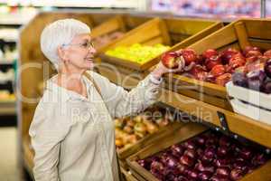 Senior woman picking out red apple