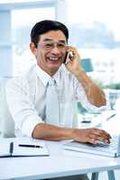 Smiling asian businessman calling someone