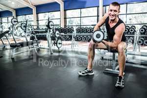 Muscular man exercising with dumbbells