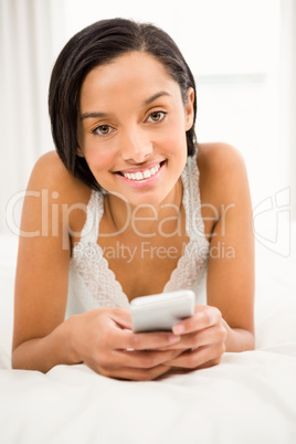 Smiling brunette using smartphone