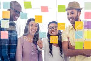 Happy creative people discussing over adhesive notes