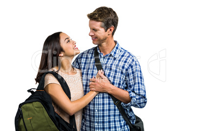 Cheerful couple with bags embracing each other