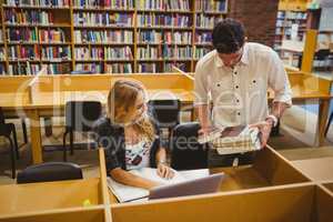 Smiling students working together while sitting at table