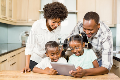 Happy family using tablet in kitchen