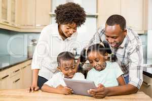 Happy family using tablet in kitchen