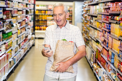 Senior man with grocery bag using smartphone