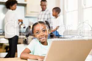 Daughter using laptop in the kitchen