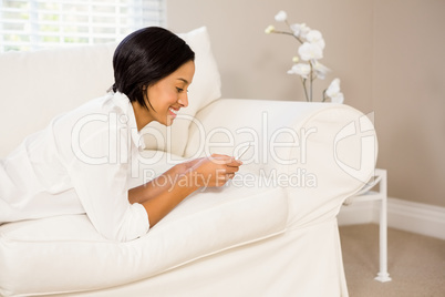 Smiling brunette using smartphone