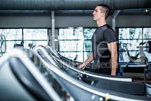 Concentrated muscular man using treadmill