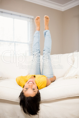Smiling brunette on sofa with legs up