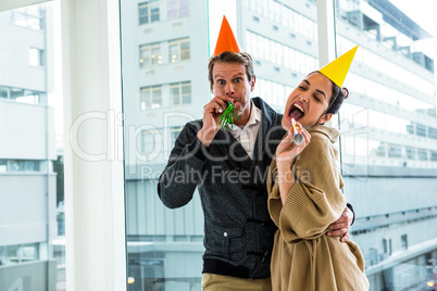 Cheerful couple celebrating birthday against glass window