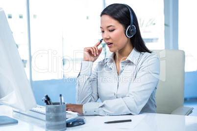 Concentrated businesswoman with headset using computer