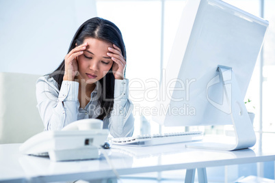 Unsmiling businesswoman with hands on head