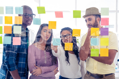 Creative team discussing over adhesive notes