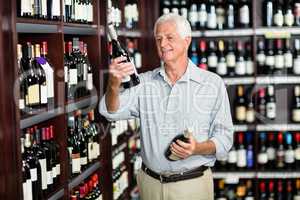 Smiling senior man choosing wine