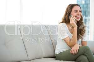 Happy woman calling on sofa