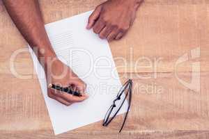 Businessman writing on paper at desk