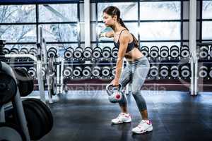 Serious fit woman lifting kettlebell