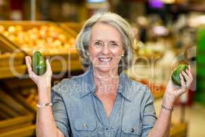 Senior woman holding two avocado