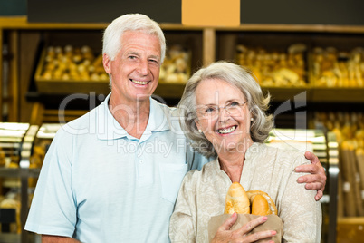 Senior couple holding bakery bag