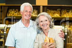 Senior couple holding bakery bag