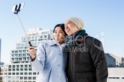 Playful couple taking selfie against building