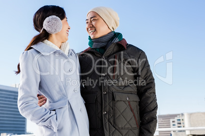 Happy couple in warm clothing looking at each other
