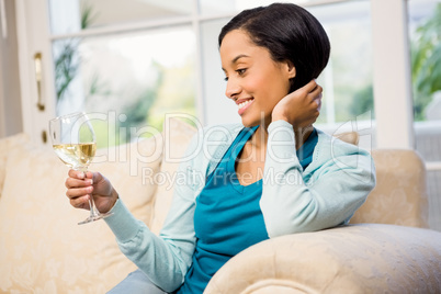 Smiling brunette holding glass of white wine