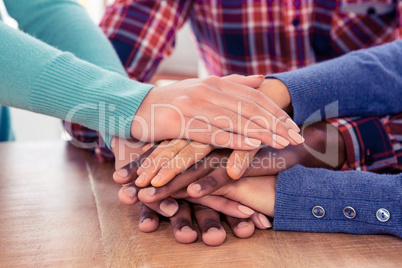 Business people with stacked hands on desk