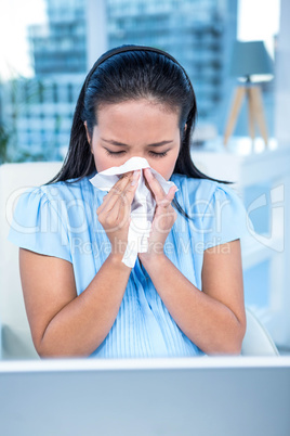 Businesswoman blowing her nose