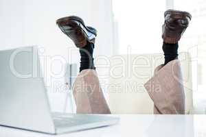 Businessman lying on the ground with feet up