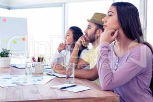 Colleagues day dreaming while sitting in conference room
