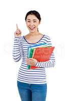 Cheerful woman pointing up while holding files